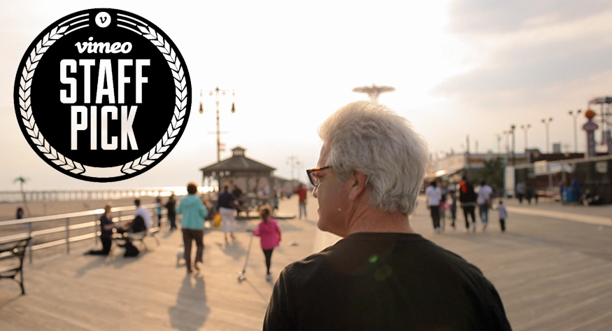 man with grey hair at waterfron boardwalk