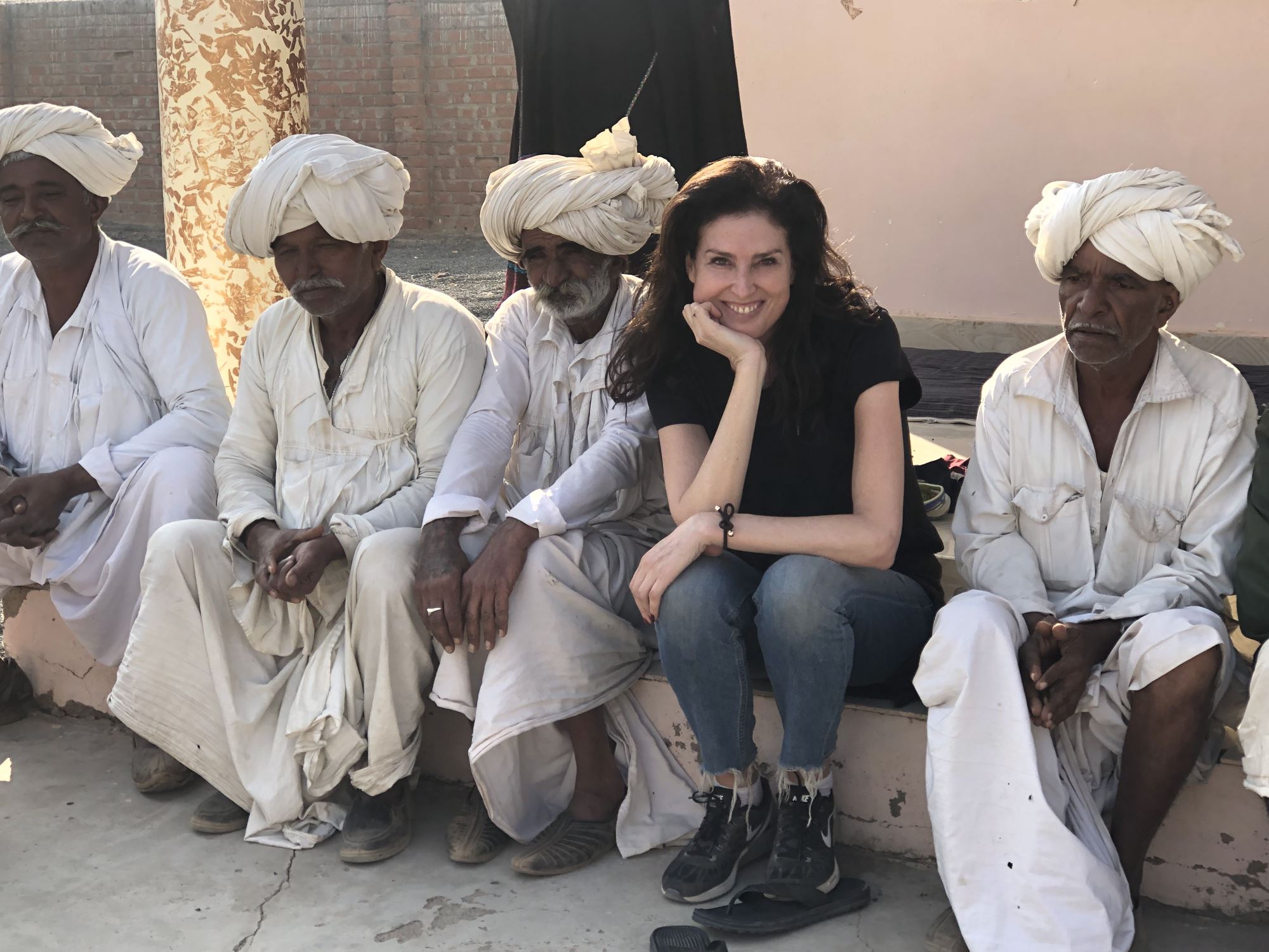 Peyton sitting with Indian men